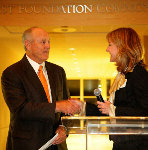 SMU Cox Assistant Dean of Marketing and Communications Lynda Oliver congratulates baseball hall of famer Nolan Ryan on being named 2012 CEO of the Year at the unveiling ceremony held at the Collins Center.